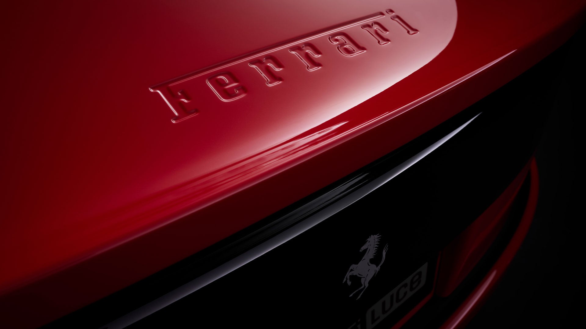 Close-up of a Ferrari logo with the Italian flag colors above the black prancing horse on a yellow background.